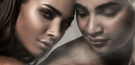 Beauty portrait of sensual beautiful couple. Caucasian woman with glamour makeup posing with handsome african american man.の写真素材