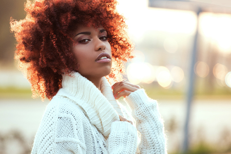 Autumn outdoor portrait of beautiful african american girl with afro hairstyle.の写真素材