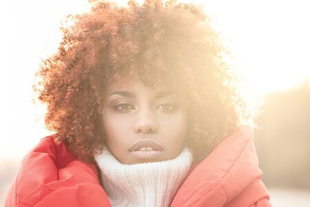 Autumn outdoor portrait of beautiful african american girl with afro hairstyle.の写真素材