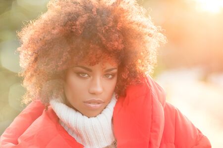 Autumn outdoor portrait of beautiful african american girl with afro hairstyle.の写真素材