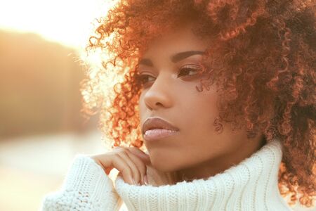 Autumn outdoor portrait of beautiful african american girl with afro hairstyle.の写真素材