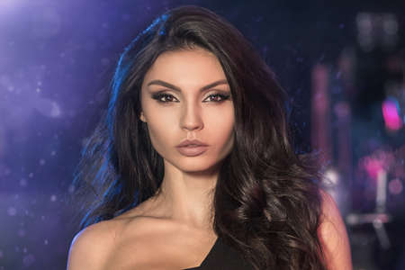 Portrait of beauty young female model with long dark hair and glamour makeup.