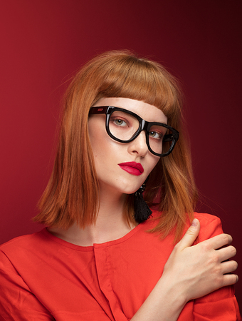 Colorful portrait of redhead young beautiful woman. Girl wearing fashionable eyeglasses.の写真素材