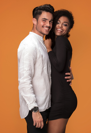 Happy beautiful mixed race couple. Smiling african american girl with handsome man posign together.の写真素材