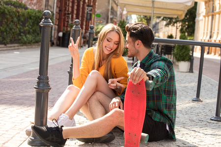 Photo of a happy young beautiful couple with skateboards having fun together in the city.の写真素材