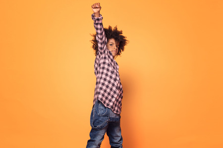 African american little man in fashionable shirt. Studio shot. Young boy posing on yellow background.の写真素材