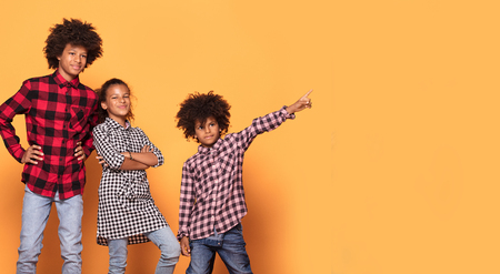 Happy smiling three afro children in colorful clothes posing together, smiling, having fun.の写真素材