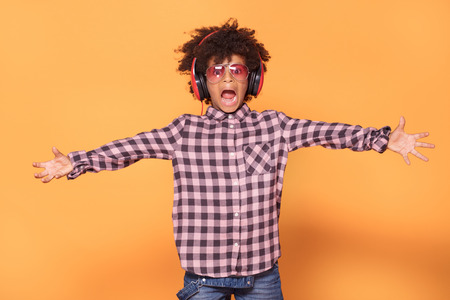 African american little man in fashionable shirt. Studio shot. Young boy posing on yellow background.の写真素材