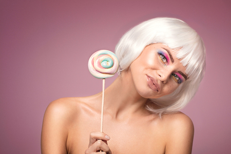 Beauty portrait of attractive woman in colorful glamour makeup and white wig.の写真素材