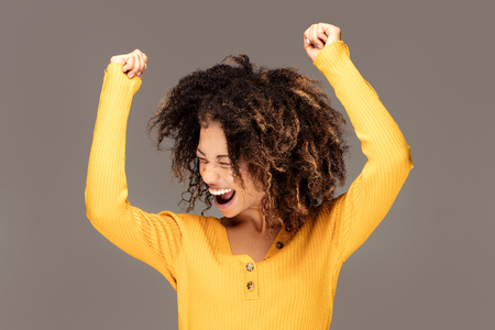 Happy african american woman smiling. Beautiful female half-length portrait. Young emotional afro woman. The human emotions, facial expression concept.の写真素材