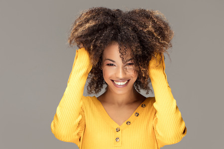 Happy african american woman smiling. Beautiful female half-length portrait. Young emotional afro...