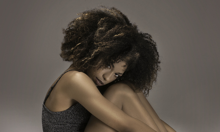 Fashionable attractive african american woman with afro hairstyle posing.の写真素材