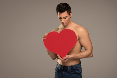 Handsome shirtless man posing with red heart, valentine's day.の写真素材