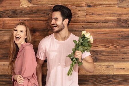 Romantic date. Handsome man giving flower bouquet to beautiful woman. Smiling people having fun together. True feelings. Human emotions and expression concept.の写真素材