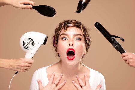 Beautiful woman and professional hairdressers artists hands with different equipment. Closeup beauty portrait of attractive girl with glamour face.の写真素材