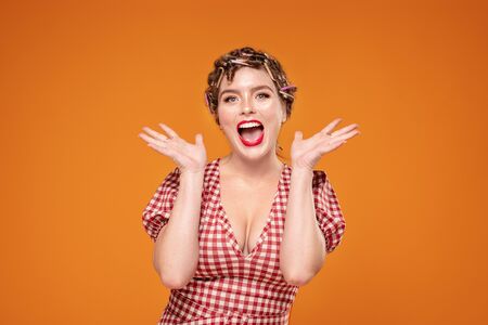 Crazy beautiful girl with rollers on head and glamour makeup smiling to the camera. Human expression, emotions concept. A lot of copy space.の写真素材