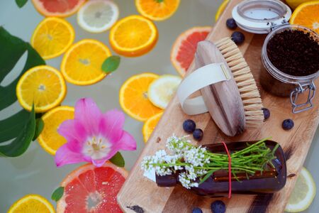Relaxing bath with grapefruit, lemon, oranges slices and flowers. Beauty treatment. Wellness conceptの写真素材