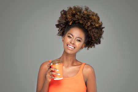 Beautiful african woman laughing and looking at camera with joy. Beauty afro american girl with curly hair smiling.の写真素材