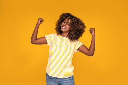 Young beautiful African afro woman with curly hair smiling.