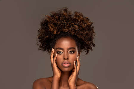 Beauty portrait of woman with afro posing in studio.