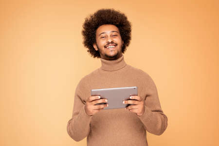 Happy African Man Holding Tablet Computer and smiling.の写真素材