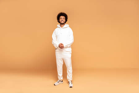 Studio shot of young handsome African man wearing fashionable tracksuit.