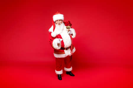 Christmas are coming! Real Santa Claus posing on red studio background.の写真素材