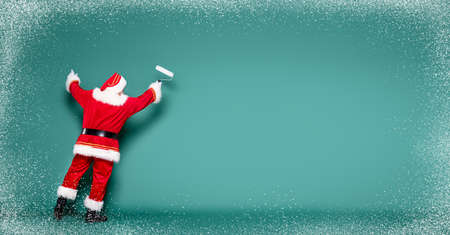 Christmas are coming! Real Santa Claus is getting ready for the season, painting the wall.の写真素材