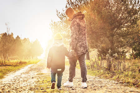 Father and son walking and having fun in autumn beautiful park. Concept of family, happiness, childhood, lifestyle.の写真素材