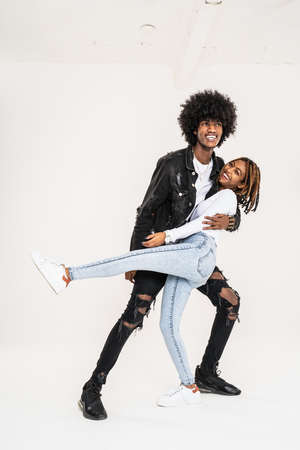 Positive, smiling african couple dancing and laughing, having fun together. Fashionable young happy people.の写真素材