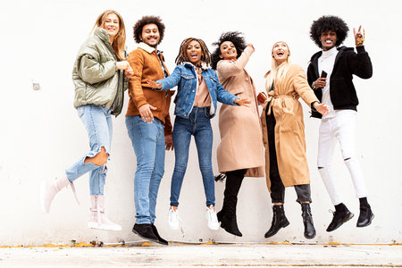 Photo of multiethnic group of happy young friends smiling and having fun together outdoor....
