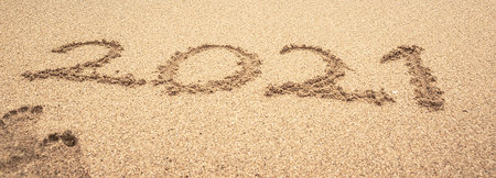 Inscription 2021 on the seashore. Beach sand. Concept of the new 2021.