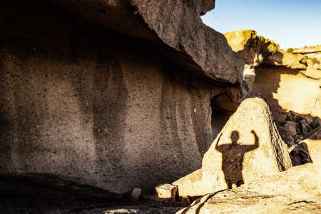 Conceptual photo, shadow of a successful man on a rocky mountains.の写真素材