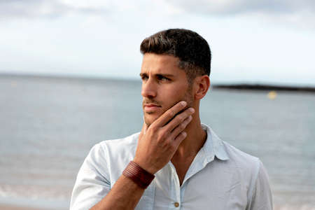 Portrait of handsome young italian man posing outdoor on the coast.