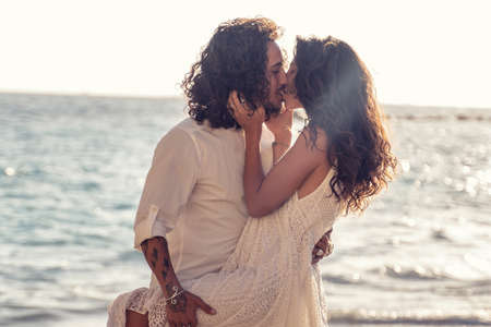 Happy cheerful couple kissing and hugging on the beach, spending time together. Island summer vibes....