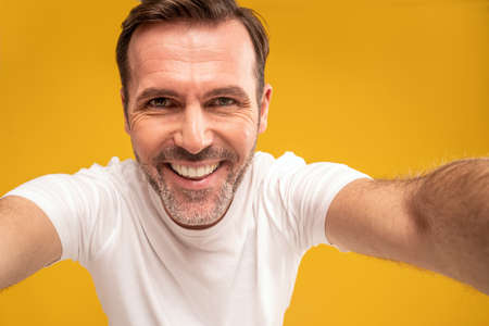 Closeup portrait of smiling handsome man looking at camera and taking selfie photo. Selfie concept....