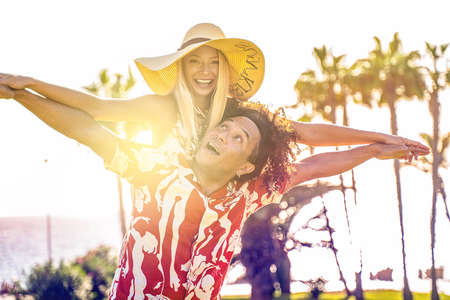 Summer beautiful multiethnic couple laughing, having fun together on a date outdoor. People in love. Honeymoon. Holidays romance. Sunny day. Real emotions. Happiness.の写真素材