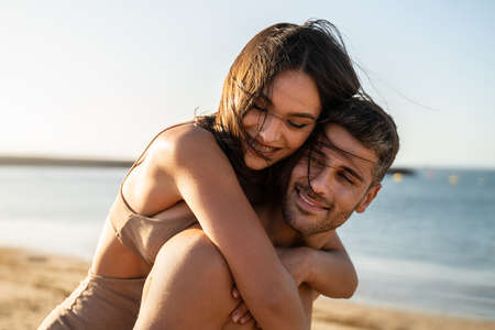 Portrait of lovely couple in love having fun on the beach. Young beautiful people hugging. Romantic moment. Valentine's day. Honey moon.の写真素材