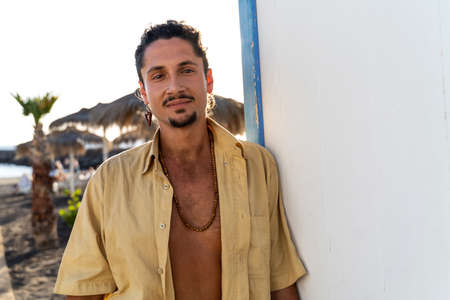 Portrait of calm handsome hippie italian man with smile looking at the camera, relaxing on the beach. Wanderlust. Tropics. Traveler. Relax. Tourism.の写真素材