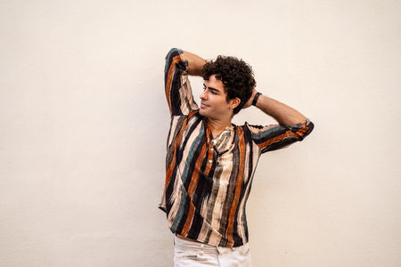 Handsome spanish man posing over wall. Fashionable hipster. Relax. Real people emotions.の写真素材