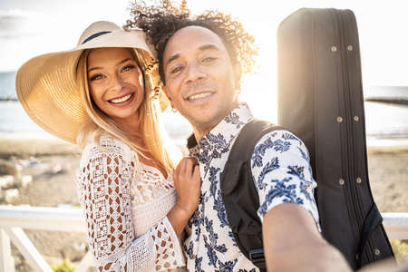 Portrait Of beautiful happy multiracial couple having fun together on the beach. Leisure time. Summer. Real people emotions.の写真素材