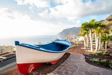 View point of colorful fishing boat near the ocean coast in Los Gigantes, Tenerife, Canary Islands. Summer vibes. Tourism. Travel. Postcard.の写真素材