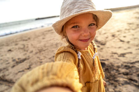 Happy little girl in hat taking selfie at tropical beach on Tenerife island during summer vacation. Travel. Tourism.の写真素材