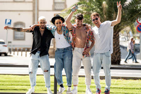 Group of young fashionable friends having fun together in the city, playing, laughing and making content for social media. Four people. Friendship. Happiness. Real people lifestyle.の写真素材