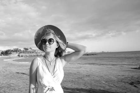 Beautiful boho woman enjoying summer vacation, walking at the beach. Portrait of blonde woman...