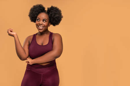 Active plus size woman after training in fashionable sporty clothes posing together, smiling. Real...
