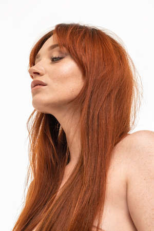 Natural ginger woman with long hair and freckles. Beauty portrait. Studio shot.の写真素材