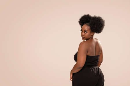 Beauty portrait of beautiful woman looking at the camera. Afro hairstyle, glamor makeup. Studio Background. Fashionable girl. A lot of copy space.の写真素材