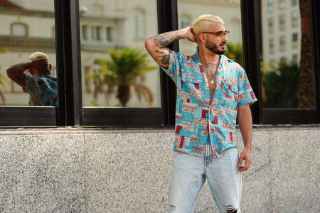 Photo of fashionable young man in casual shirt posing outdoor. Handsome man with beard on the city street. Tourist.の写真素材
