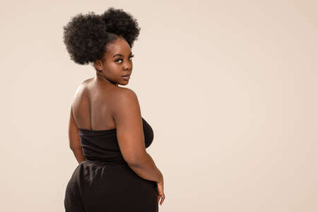 Beauty portrait of beautiful woman looking at the camera. Afro hairstyle, glamor makeup. Studio Background. Fashionable girl. A lot of copy space.の写真素材